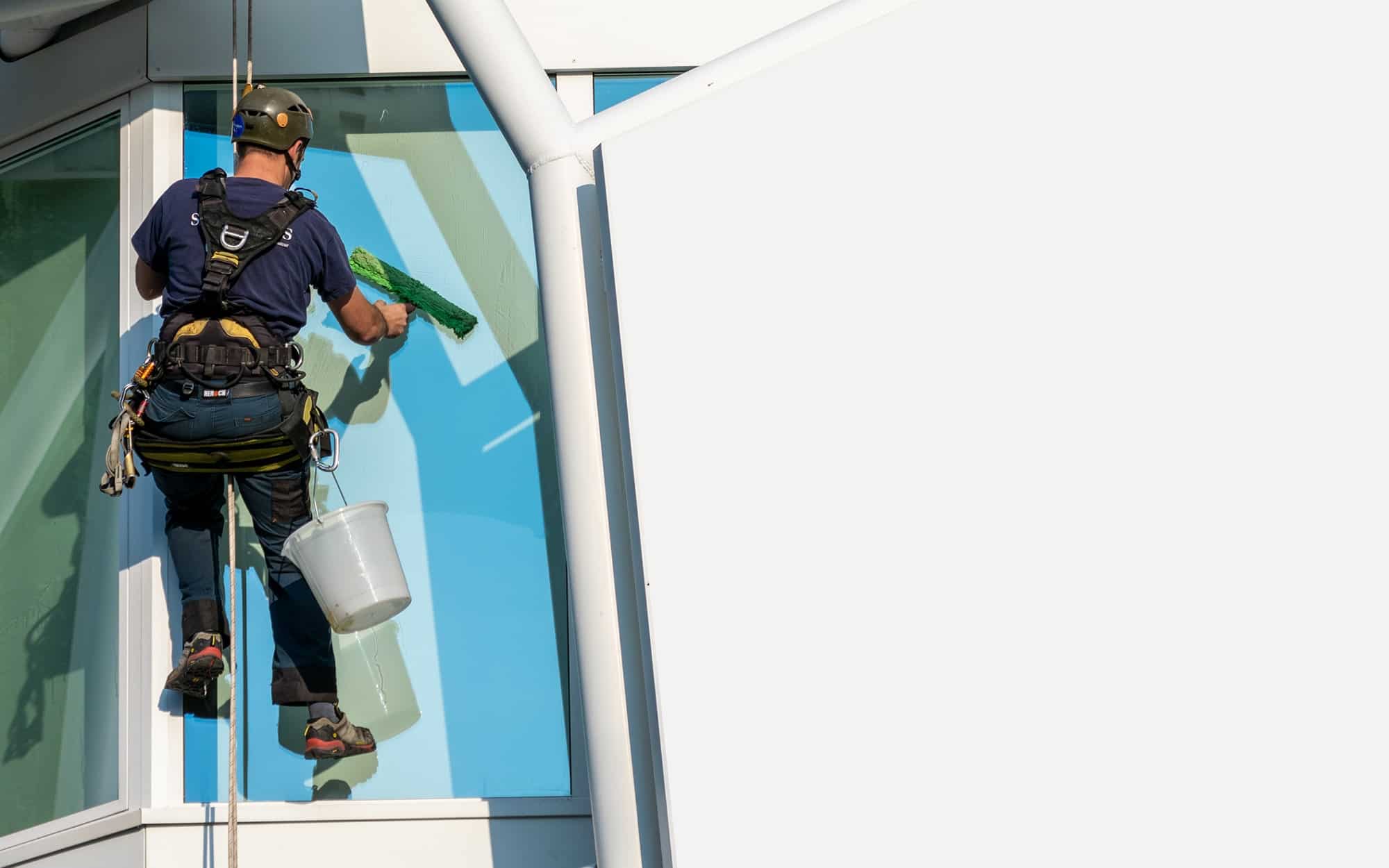 Nettoyage de vitres en hauteur Un cordiste réalise un nettoyage en hauteur